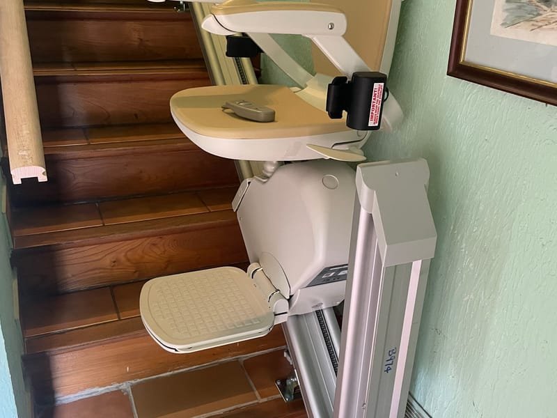 Monte-escalier installé sur un escalier intérieur, siège replié en haut des marches