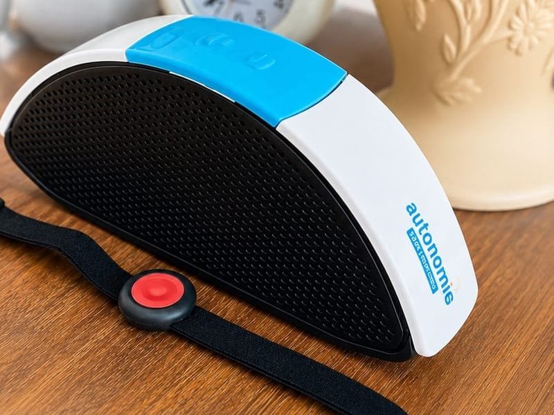 Transmetteur de téléassistance et bracelet d'alerte posés sur une table