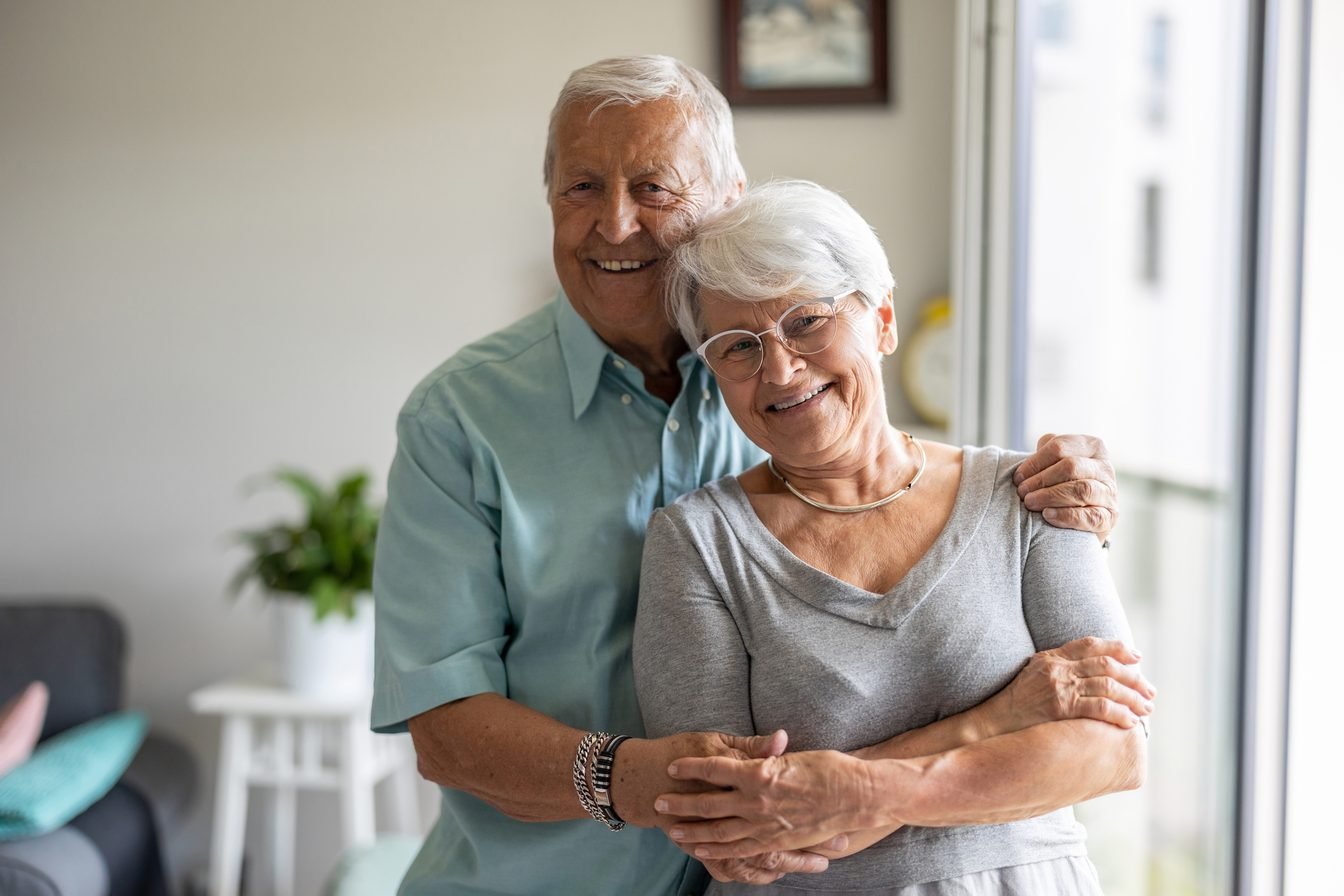 Couple de seniors souriants à leur domicile à Montpellier, environnement adapté